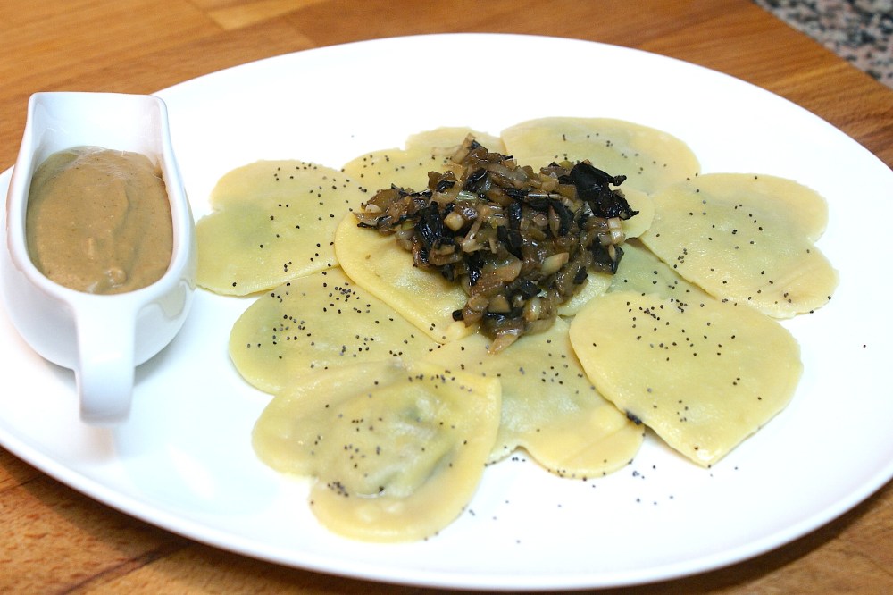 Ravioli de pasta fresca casera de calabaza relleno de trompetillas, ajos tiernos y berenjena